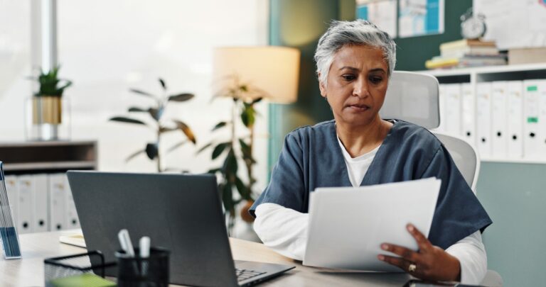 Professionnelle de santé examinant des documents à son bureau