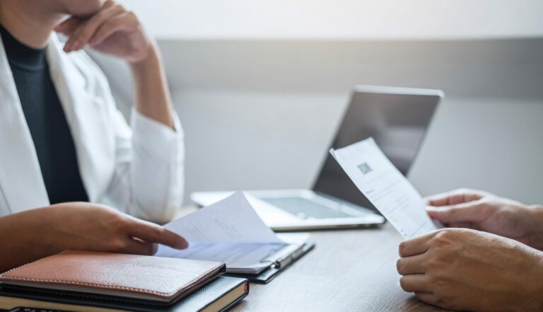 Deux personnes comparant des relevés au-dessus d'un bureau