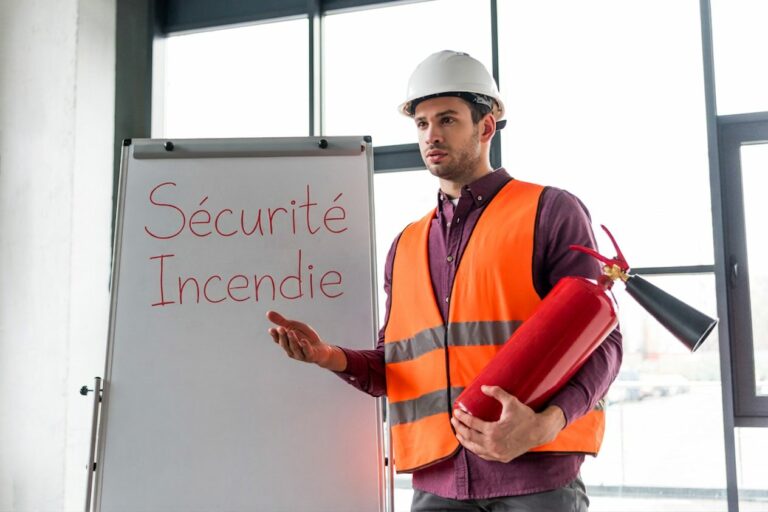 Formateur en gilet de sécurité présentant un extincteur devant un paperboard intitulé Sécurité Incendie