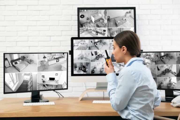 Opératrice de sécurité surveillant un mur d'écrans de vidéosurveillance