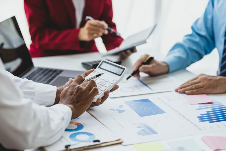 Réunion de travail autour d'une calculatrice et de tableaux financiers
